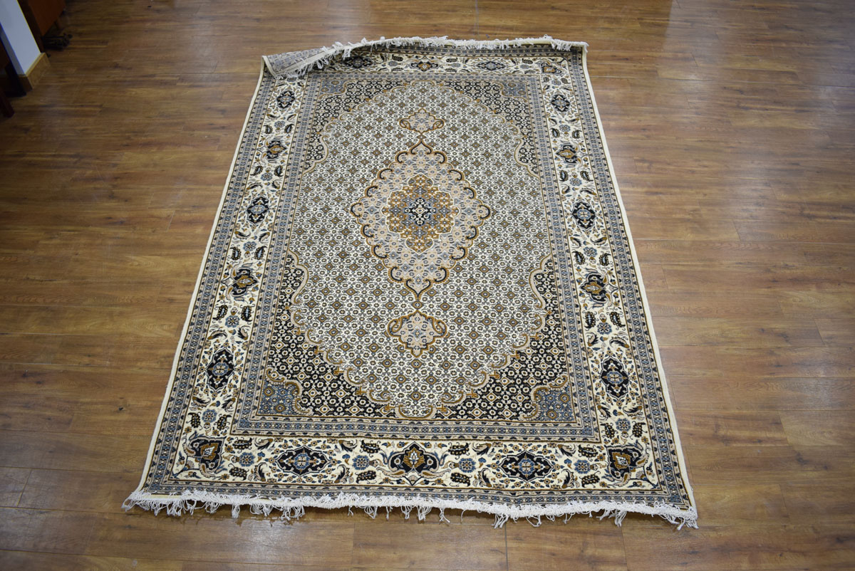 An Iranian carpet, the beige and blue ground with repeated diamond motifs,