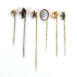 An early 20th century stick pin set four small diamonds and cabochon green tiger's eye, l. 5.