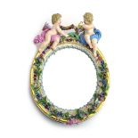 A late 19th/early 20th century Meissen florally encrusted wall mirror of oval form decorated with a