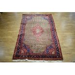 An Iranian carpet, the brown, red and blue ground with repeated diamond motifs and abstract bands,