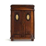 An early/mid 20th century miniature oak wardrobe, the pair of doors enclosing a fitted interior, h.
