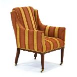 An Edwardian and later upholstered armchair with mahogany strung tapering legs on castors