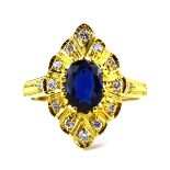 An 18ct yellow gold ring set oval sapphire and twelve small diamonds in a marquise shaped setting,