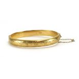 A 9ct yellow gold and florally engraved hinged bracelet, maker JS, Birmingham 1976, internal w. 6.
