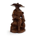 An Oriental hardwood carving modelled as a gentleman at rest, his hat detachable, h. 17.