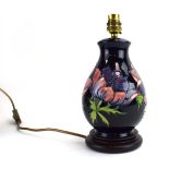 A Moorcroft table lamp base of ovoid form decorated with anemone on a blue ground, h.