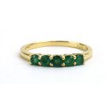A 9ct yellow gold ring set five emeralds in an inline setting, by Jacques Christie, ring size Q, 1.