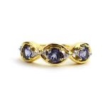A 9ct yellow gold ring set three blue spinel and white zircon in oval settings by Jacques Christie,
