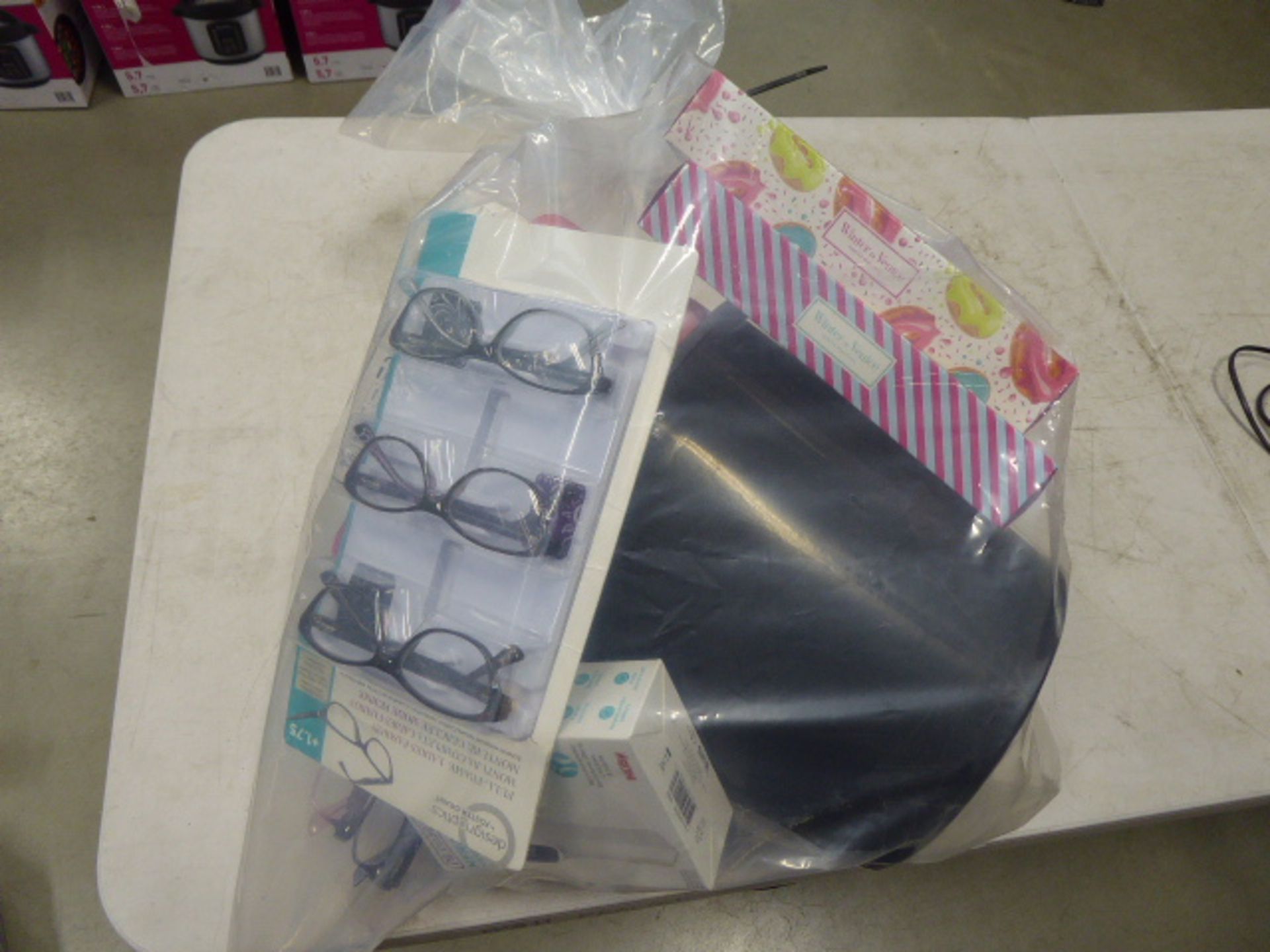 Bag containing bucket, bath bombs, reading glasses, thermometers, etc.