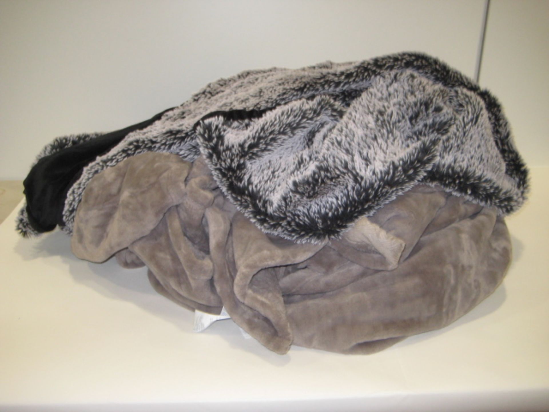 Bag containing 2 large throws, 1 light brown, 1 mottled grey and white