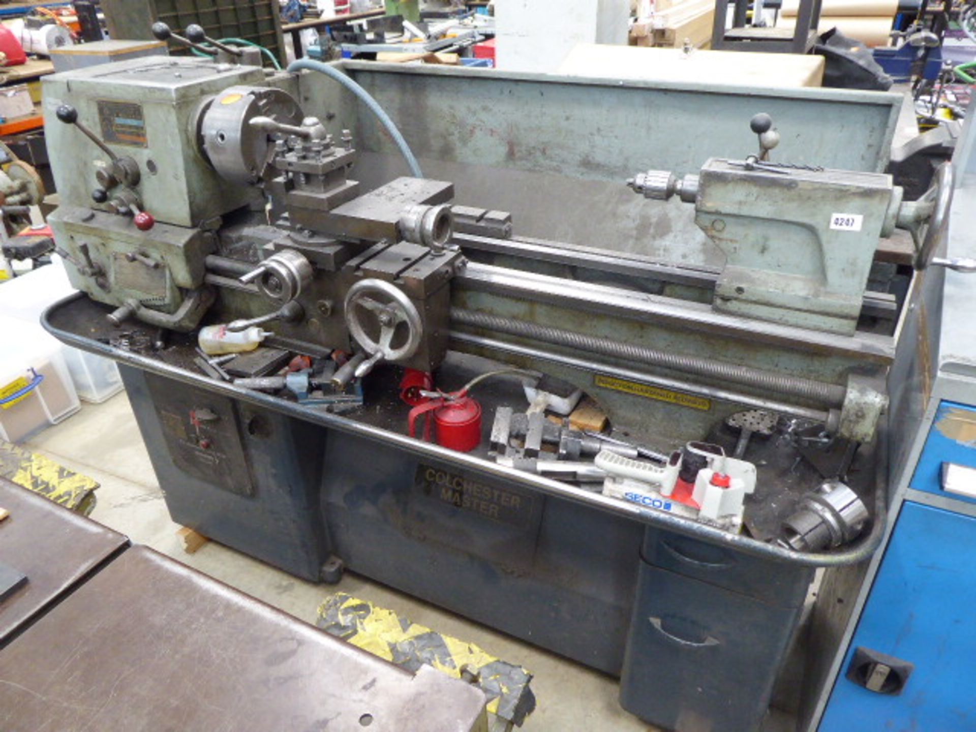 Colchester Master centre lathe with a grey and blue metal tool cabinet, two machine vices and a