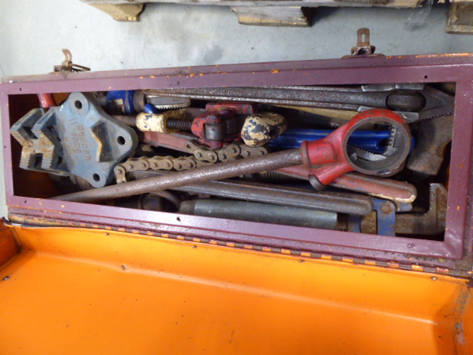Large metal box on wheels containing pipe cutters, pipe threaders and stilsons