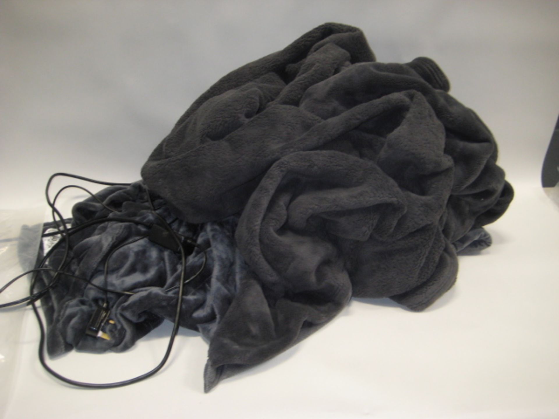 Bag containing large grey faux fur throw with bluey grey heated blanket