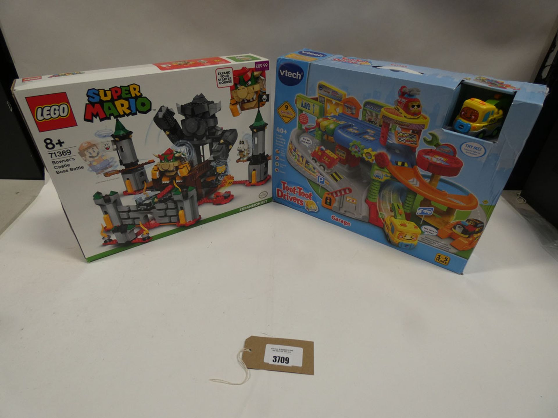 Lego Super Mario bowser's castle boss battle expansion set together with V-Tech toot-toot drivers