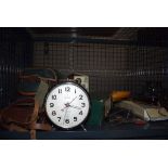 A cage containing an alarm clock, quartz clock, quantity of cameras and a camera bag