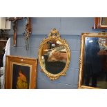Oval mirror in ornate gilt painted frame