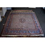 (27) An Iranian wool carpet with geometric patterns in cream ground and blue border, approx 200 x