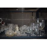 A cage containing a glass fruit bowl, jugs, glasses, bottles and an ornamental figure of a