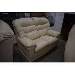 Cream faux leather three seater sofa together with two similar two seater sofas and an armchair