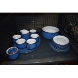 A cage containing a quantity of blue glazed Denby crockery