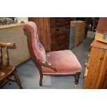 Early 20th century walnut framed nursing chair in pink buttoned upholstery In need of attention