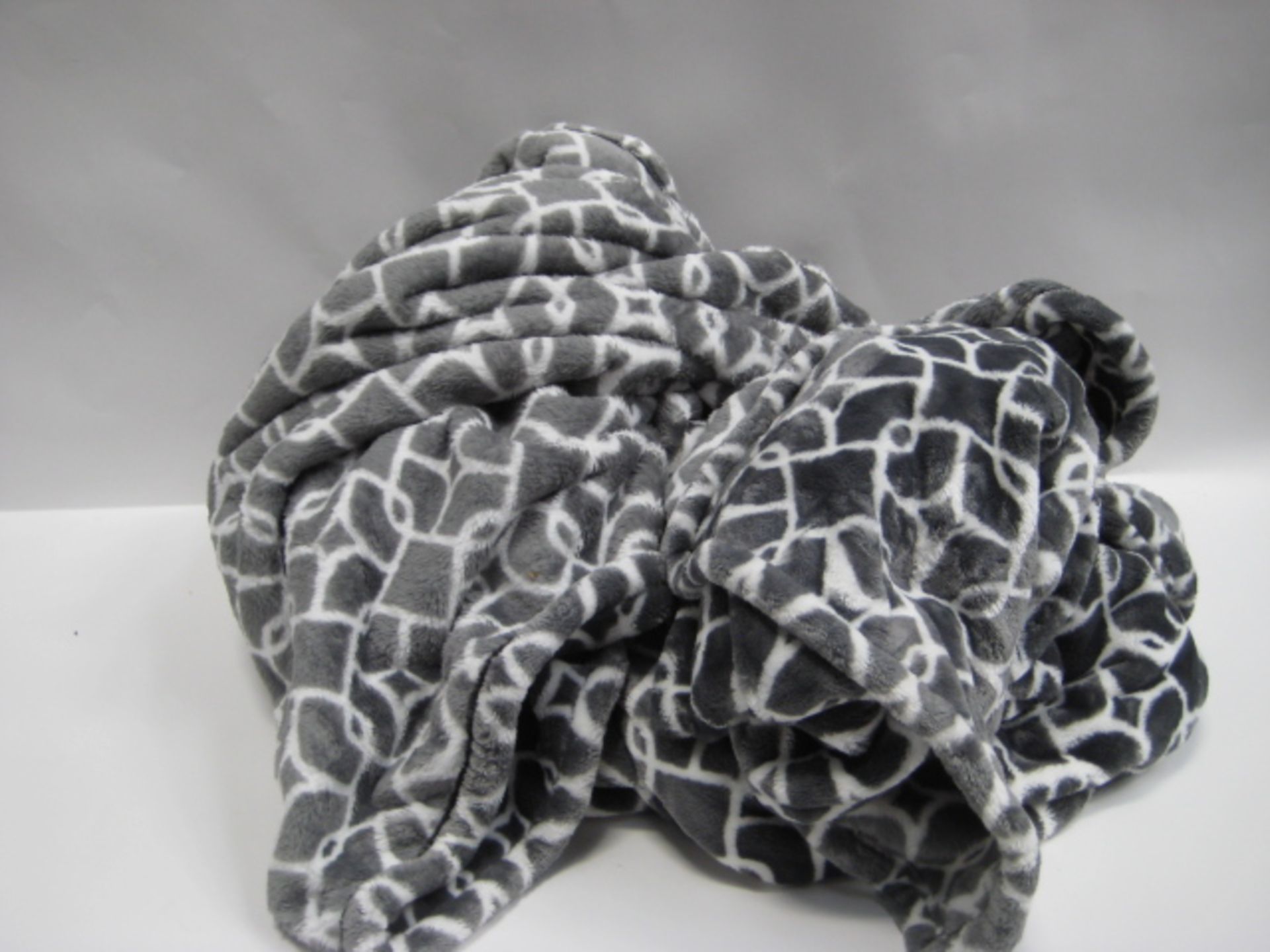 Two grey and white patterned throws