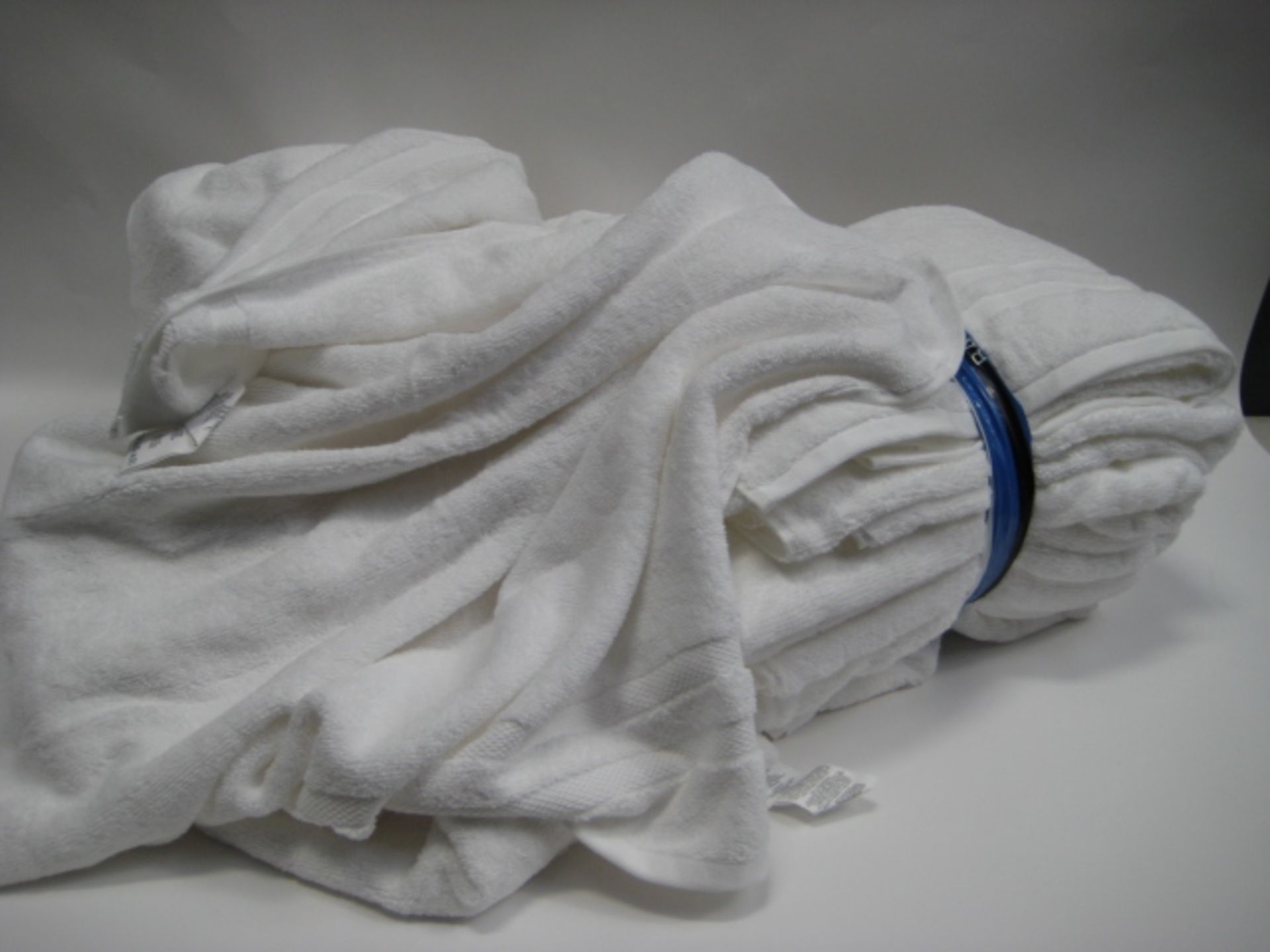Bag containing a qty of white towels, mostly bath towel sized