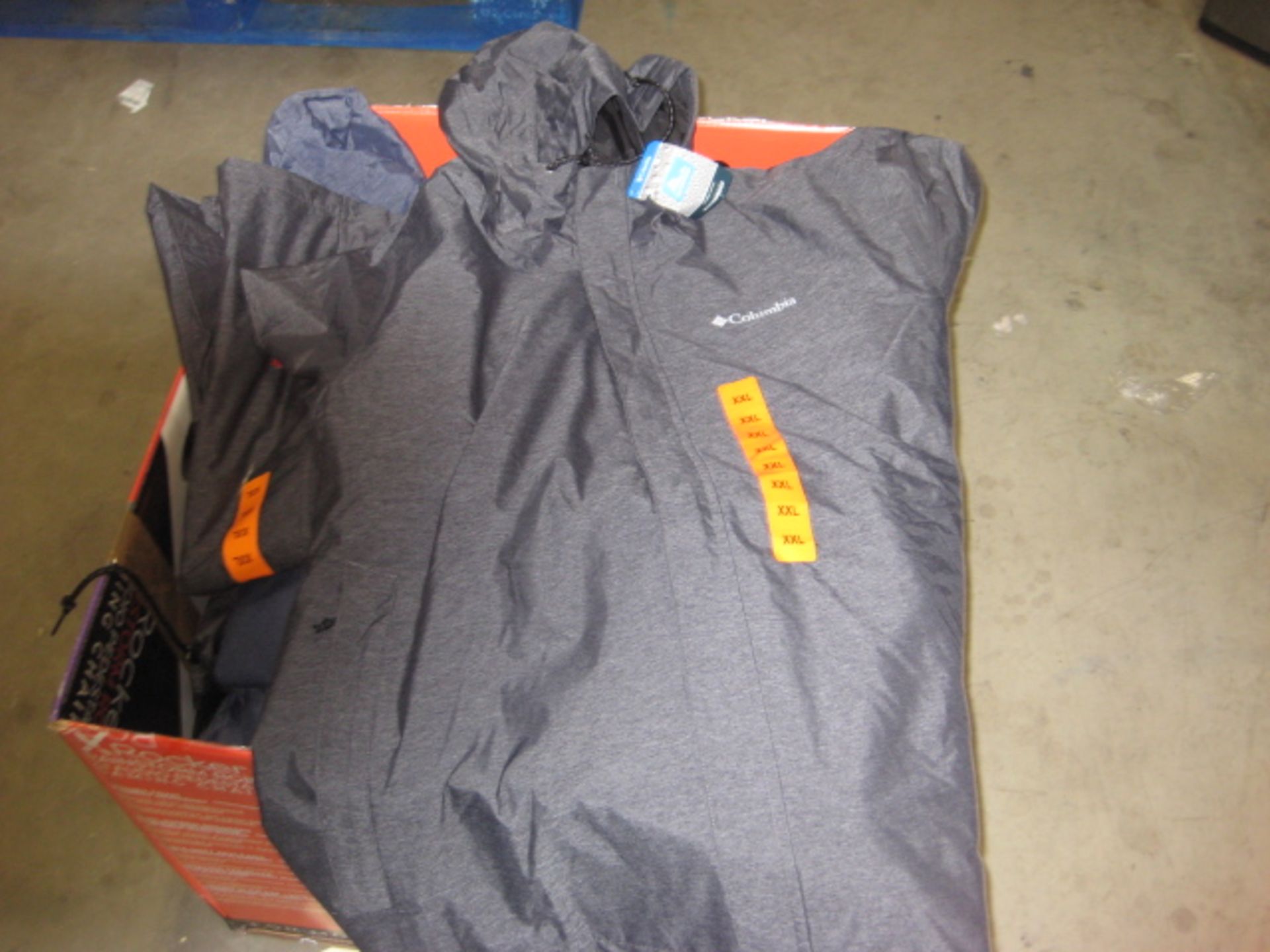 Box containing 20 Columbia light weight hooded rain jackets in grey and blue