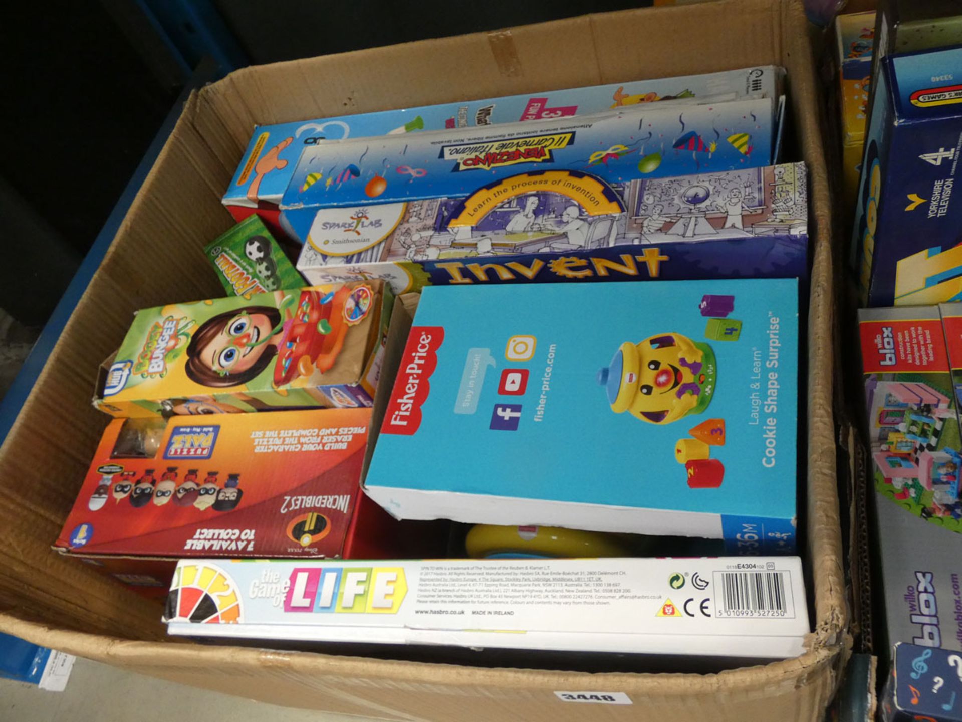 Box containing a Fisher Price game, bogie bouncer, Incredibles 2, etc
