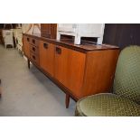 A 1970's teak sideboard of three drawers, two doors and a fall front section, w. 198 cm Fair
