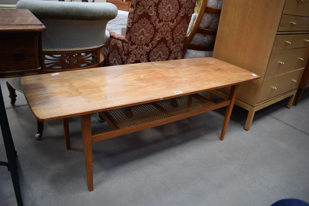 A 1970's teak coffee table with caned second tier, w. 128 cm Cane is intact. Heat/water marks