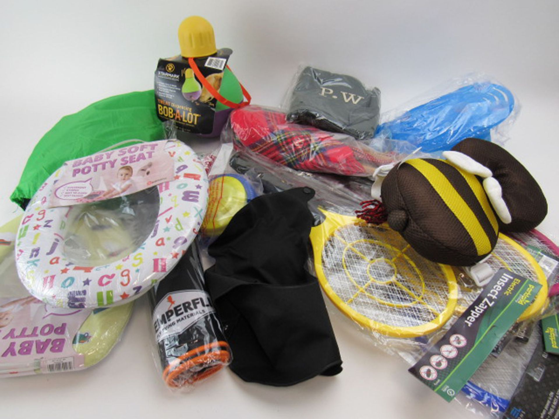 Bag containing insect zappers, Semperfli fly tying kit, Baby's Soft potty seats, dog treat toy, etc.