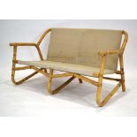 A 1970's bamboo two-seater sofa with loose cushions *Sold subject to our soft furnishings policy