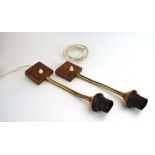 A pair of Swedish wall lights with teak mounts and brass flexible stems,