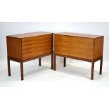 A pair of 1970's teak cabinets with fall-fronts on square legs, one enclosing a mirrored interior,