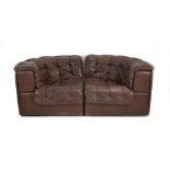 A 1970's De Sede brown leather two-section modular sofa on a mahogany plinth base *Sold subject to