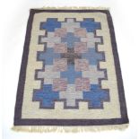 A 1960/70's Swedish Rollakan rug in a blue and purple geometric design,