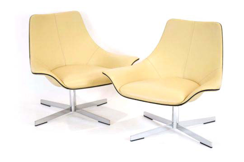 A pair of Matteo Grassi 2Leather cream lowback armchairs on four-star aluminium swivel bases *Sold