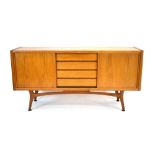 A 1960's teak sideboard, the four central drawers flanked by two sliding doors,