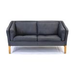 A late 20th century two-seater sofa with anthracite grey leather upholstery and a beech frame,