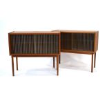 A pair of 1970's teak cabinets, each with a pair of glazed and ridged sliding doors,