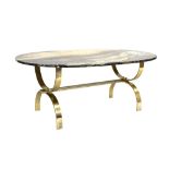 A 1970's coffee table, the oval marble surface resting on a brass-finished steel structural frame,