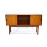 A 1970's British teak bookcase, the central section with a glass shelf,