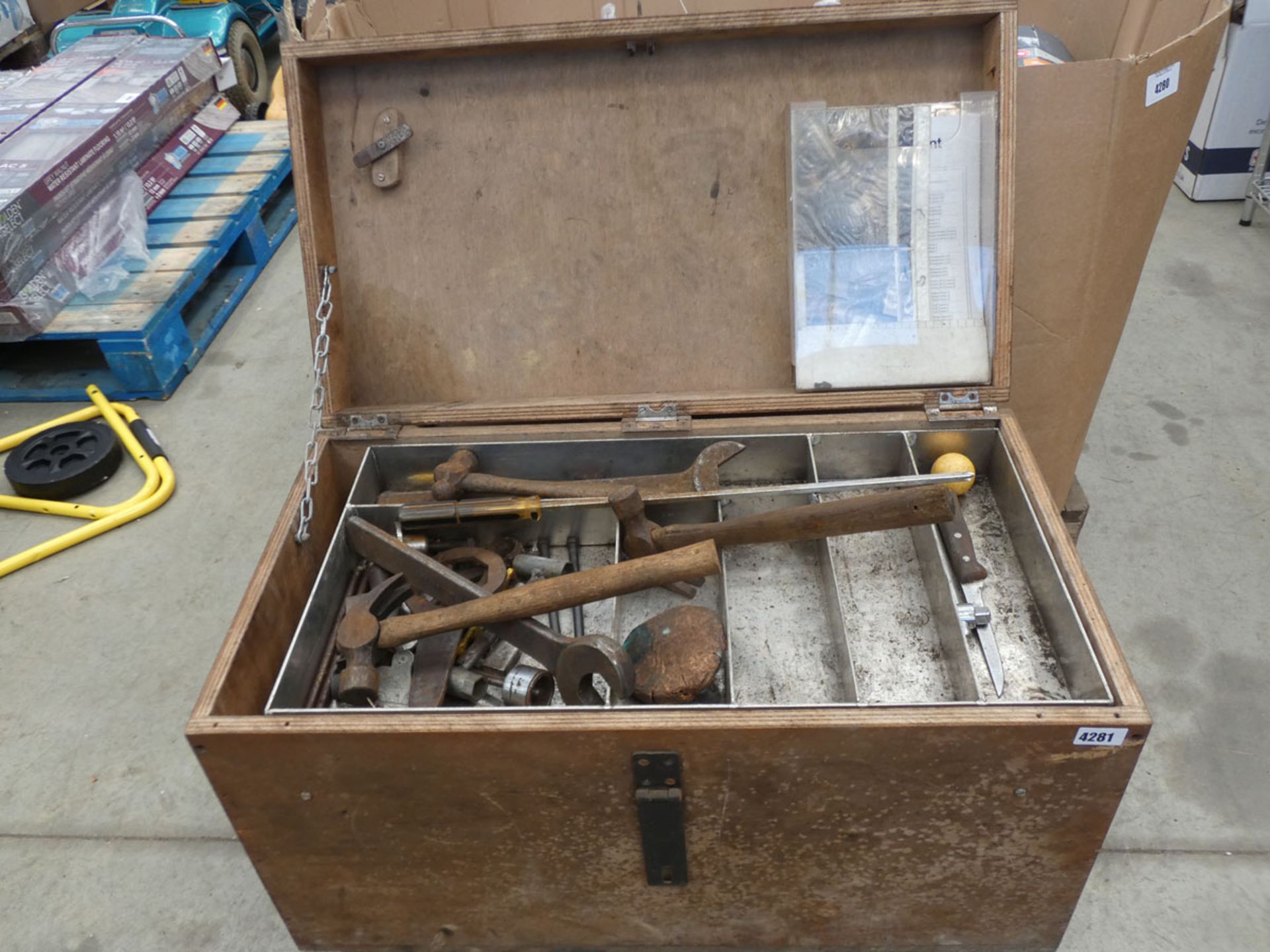 Wooden box containing large heavy duty spanners, hammers, screwdrivers, and various other tools
