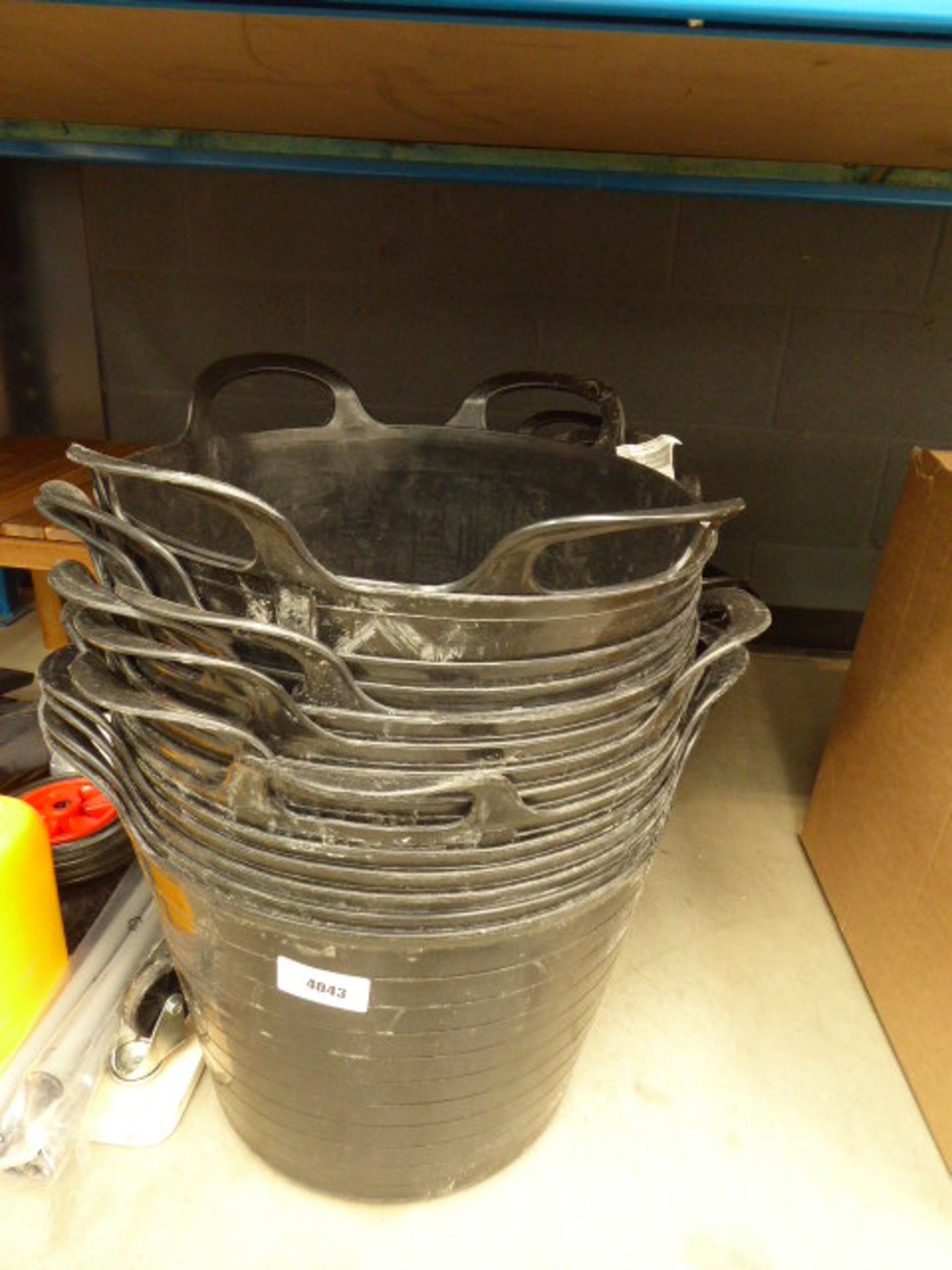 3 large stacks of black plastic buckets