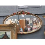 Oval bevelled mirror in floral frame