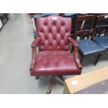 Red leather effect Chesterfield style swivel armchair