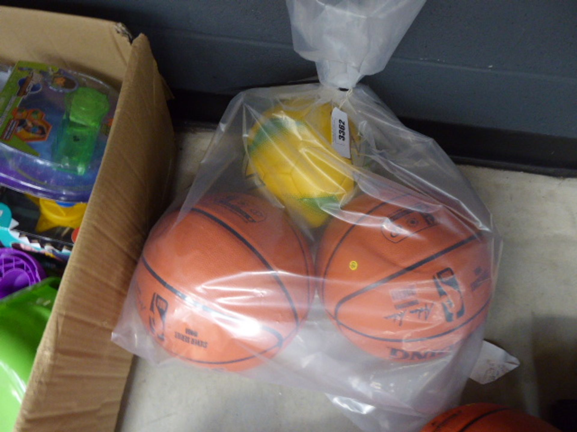 2 NBA basketballs and a yellow Mitre football