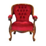 A Victorian walnut and button upholstered low back armchair on scrolled front feet