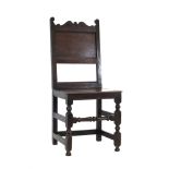 A 17th century oak back stool with a solid back inscribed 'WC' over a solid seat on block turned